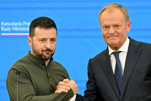 Két férfi kezet fog konferencián