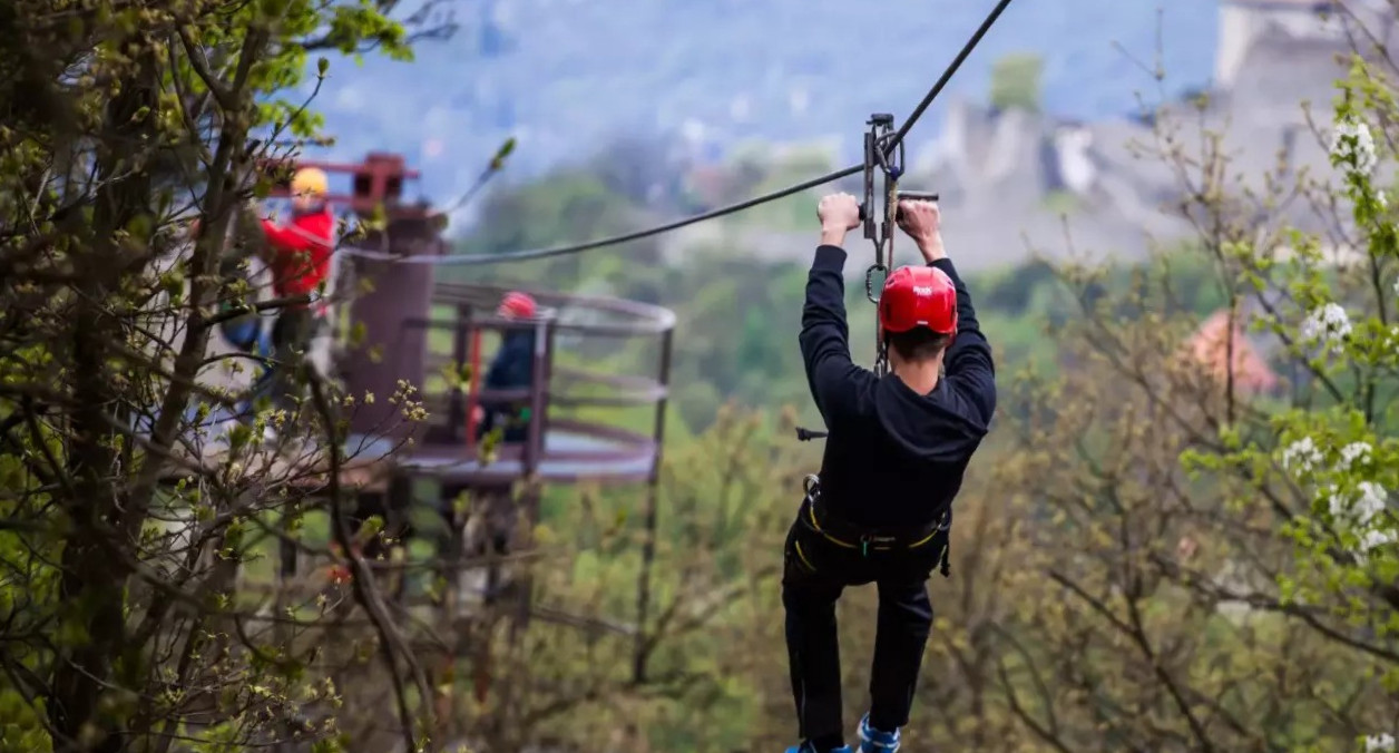 Ember zipline-on hegyvidéki környezetben.