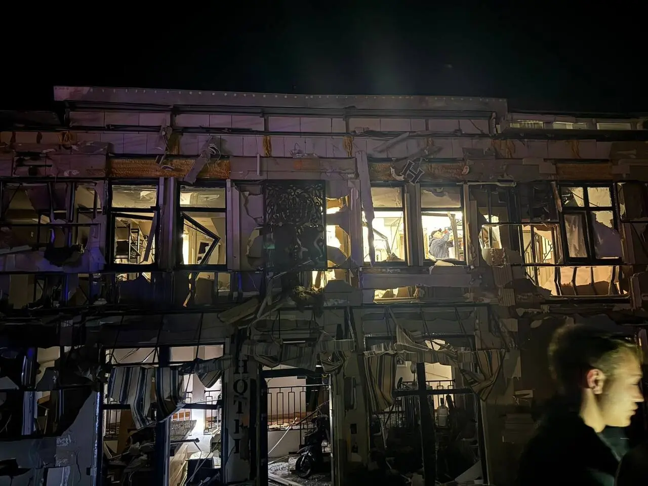 Megrongálódott épület betört ablakokkal éjszaka