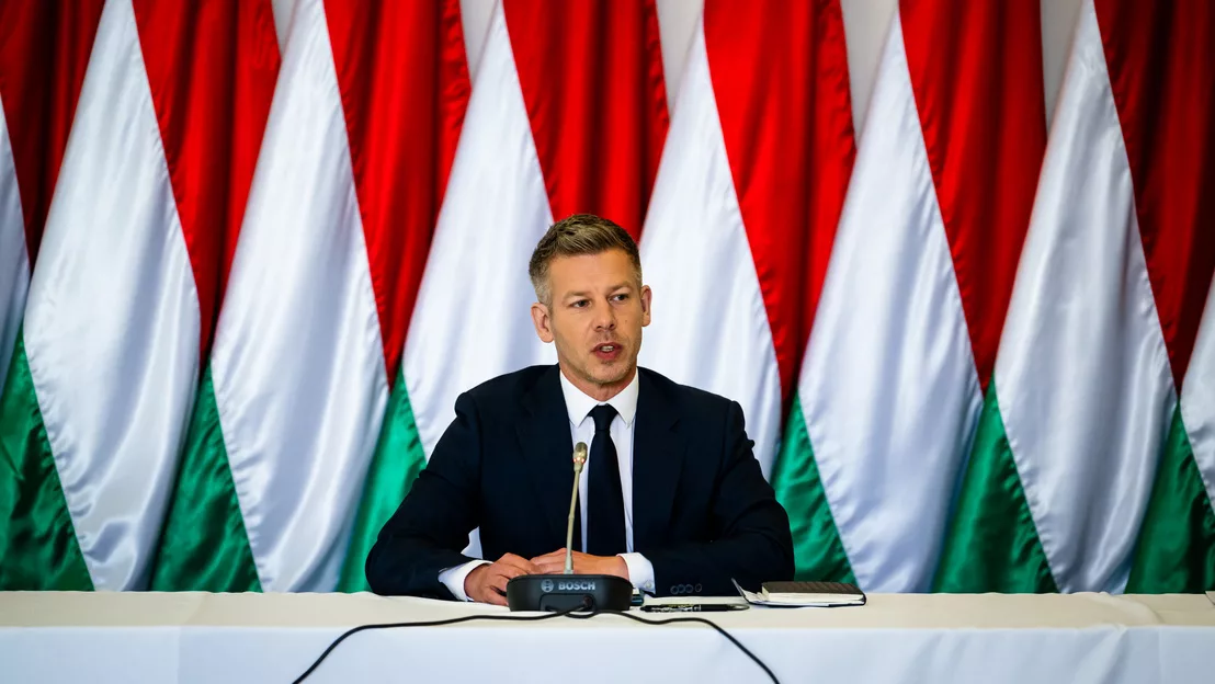 Férfi sajtótájékoztatón magyar zászlók előtt