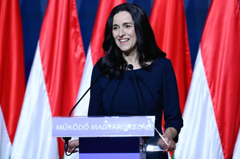 Nő beszédet mond magyar zászlók előtt