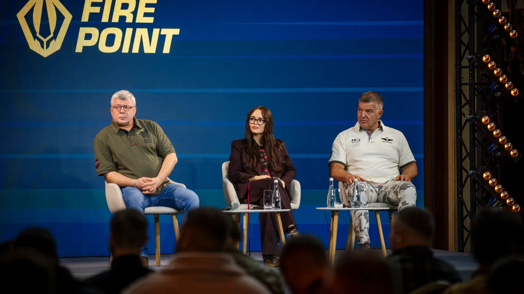 Három előadó panelbeszélgetésen színpadon