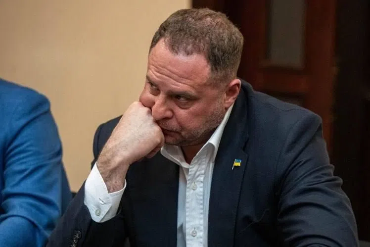 Öltönyös férfi ukrán zászló kitűzővel, gondolkodva