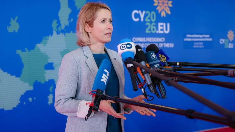 Nő sajtótájékoztatón mikrofonok előtt, EU háttérrel