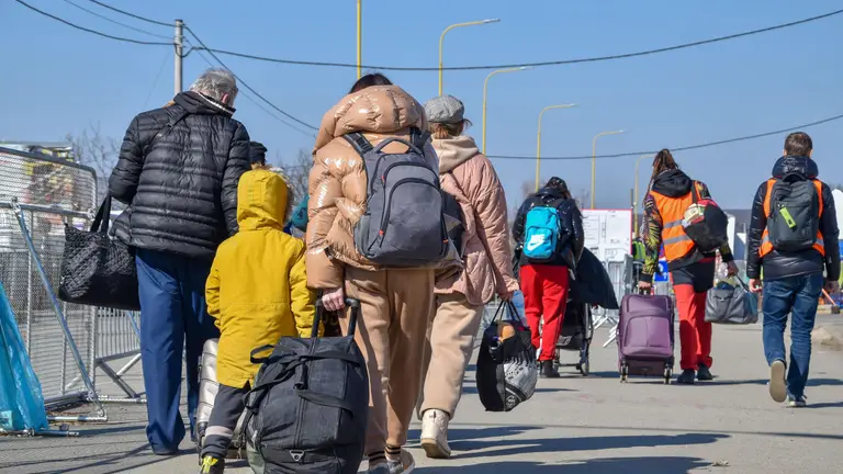 Emberek csomagokkal sétálnak egy úton