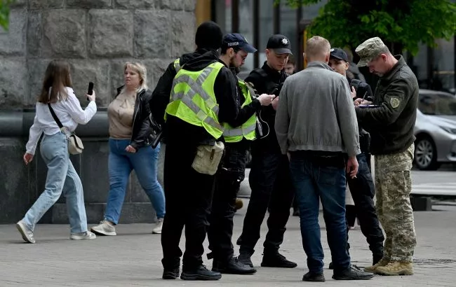 Rendőrök igazoltatnak egy férfit az utcán