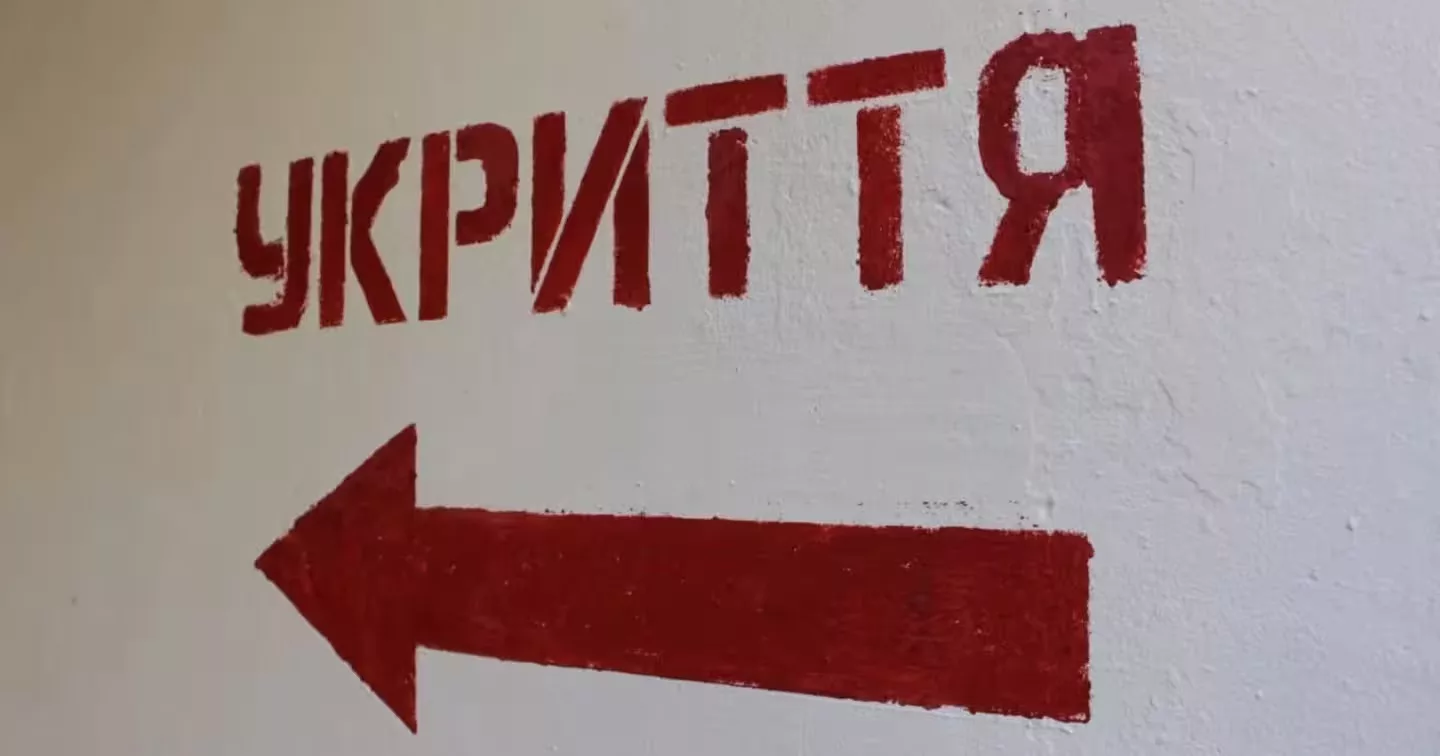 Piros ukrán 'УКРИТТЯ' felirat balra mutató nyíllal