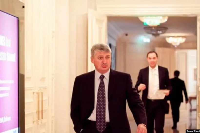 Öltönyös férfiak elegáns folyosón sétálnak